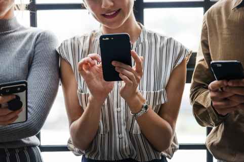 three people using smartphones